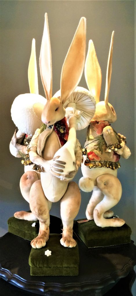 Mr Finch - three long-eared rabbits wearing exquisite handmade garments, trimmed in tiny bells and envelopes and standing on green velvet covered boxes.